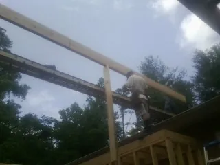 Carpenter setting a ridge beam over a new addition frame — Ice Dam Removal by Roofing Brothers in Beavertown