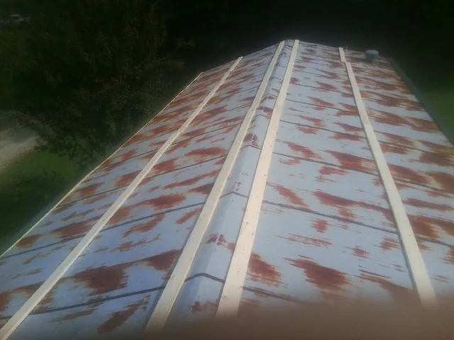 Rusted metal roof panels with new wood purlins before replacement — Storm Damage Roof Repair in Beavertown by Roofing Brothers